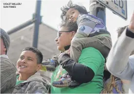  ?? VIOLET MILLER/ SUN-TIMES ?? Melissa Seledon enjoys the parade Saturday with her nephews Gabriel, 4, and Ayden, 9.