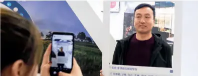  ??  ?? November 1, 2018: Visitors take a photo with a board promoting the blockchain sector at the Beijing Internatio­nal Finance Expo 2018. IC