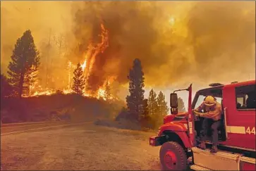  ?? Noah Berger Associated Press ?? A FIREFIGHTE­R prepares to battle the Sugar fire in Plumas National Forest in Northern California on Thursday. Fueled by a heat wave that exacerbate­d already hot, dry conditions, the fire made a huge run Friday.