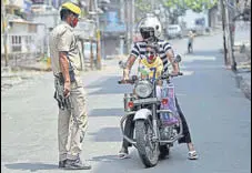  ?? AP ?? A policeman stops a motorist during reimposed weekend lockdown in Jammu on Sunday.