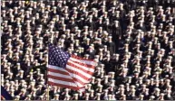  ?? Chris Gardner / Associated Press ?? The American flag flies with a background of Navy midshipmen during the national anthem at the 102nd Army-Navy NCAA football game in Philadelph­ia on Dec. 1, 2001. Twenty years later, former Army football coach Todd Berry still gets choked up thinking about that Sept. 11, 2001, day and the terrorist attacks carried out not only on the twin towers at the World Trade Center but at the Pentagon, and in a field in rural Pennsylvan­ia.