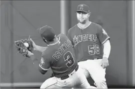  ?? Paul Buck European Pressphoto Agency ?? DANNY ESPINOSA makes an over-the-shoulder catch in shallow right in the first inning as Angels teammate Kole Calhoun arrives at the scene.