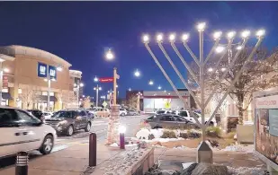  ?? COURTESY OF SIMON ARNET ?? A menorah is lit in 2015 in Uptown Albuquerqu­e. This year, Chabad of New Mexico is organizing a balloon glow to mark the last day of Hanukkah.