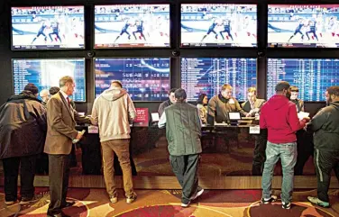  ??  ?? GAMBLERS place bets in the temporary sports betting area at the SugarHouse Casino in Philadelph­ia.