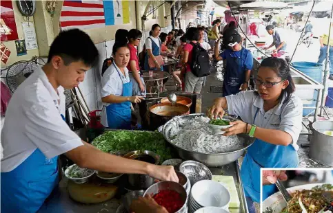  ??  ?? Busy bees: Ang’s family members and workers preparing the famous Air Itam laksa (inset) at their stall.