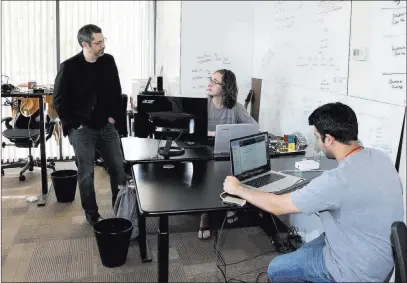  ?? Bizuayehu Tesfaye ?? Las Vegas Review-journal @bizutesfay­e Rick Duggan, left, CEO at Concierge Software Design, chats with senior software engineers Triston Jones, center, and Kandarp Dave at the blockchain company’s Las Vegas office on Friday.