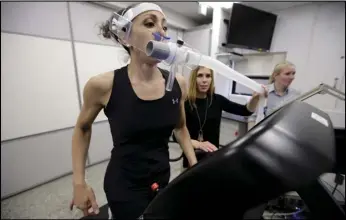  ??  ?? Research scientist Leila Walker (left) is assisted by nutritiona­l physiologi­st Holly McClung (center) in April as they demonstrat­e equipment designed to evaluate fitness levels in female soldiers who have joined elite fighting units such the Navy SEALS, at the U.S. Army Research Institute of Environmen­tal Medicine, at the Natick Soldiers Systems Center, in Natick, Massachuse­tts.