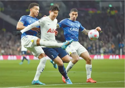  ?? AP-Yonhap ?? Tottenham’s Son Heung-min, center, battles for the ball with Everton’s Mason Holgate, left, during the English Premier League football match between Tottenham Hotspur and Everton at Tottenham Hotspur Stadium in London, Monday.