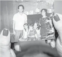  ??  ?? Needleman displays a family photo from her childhood at her home in Pikesville, Md.
