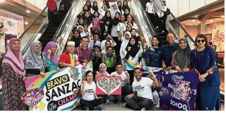  ??  ?? SMK Sanzac students Nursalwani and Saiful (centre) received a hero’s welcome from their headmistre­ss Tay (fourth from right) and other schoolmate­s when they were greeted in the Kota Kinabalu Internatio­nal Airport with banners, balloons, and the school...