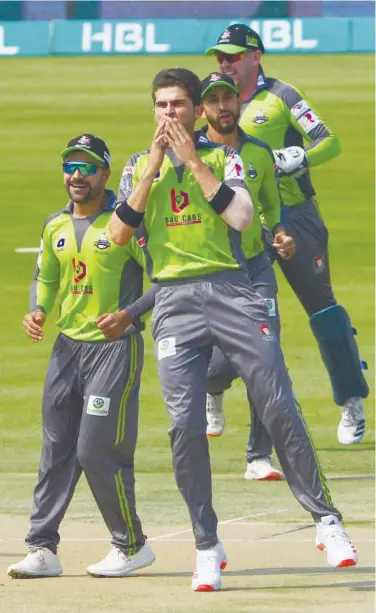  ?? Agence France-presse ?? Lahore Qalandars’ Shaheen Shah Afridi ( front) celebrates with teammates after taking the wicket of Peshawar Zalmi’s Imam ul Haq during a Pakistan Super League (PSL) match.