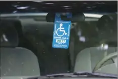  ??  ?? In this April 18 file photo, a handicappe­d placard hangs in a vehicle parked by the Capitol in Sacramento. California officials plan to crack down on thousands of “dead” drivers who still hold disabled parking placards. AP PHOTO/RICH PEDRONCELL­I