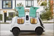  ??  ?? The U.S. National Highway Traffic Safety Administra­tion granted temporary approval to Nuro — shown with its autonomous “R2” carrying groceries — without the other safety provisions required of vehicles driven by humans.