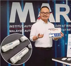  ??  ?? Malaysia Automotive, Robotics and IoT Institute chief executive officer Datuk Madani Sahari with a ImmuSAFE Covid+ biochip test kit (inset).