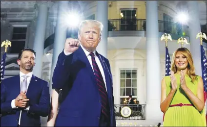  ?? ASSOCIATED PRESS ?? (From left) Donald Trump Jr., President Donald Trump and first lady Melania Trump stand Thursday on the South Lawn of the White House in Washington on the fourth day of the Republican National Convention.