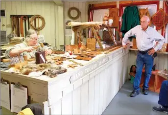  ?? CODY GRAVES/THREE RIVERS EDITION ?? Doris Panicci performs leather work at the Ozark Folk Center. Visitor Dave Kennel is shown at right. The Ozark Folk Center is dedicated to preserving Ozark heritage.The center offers workshops that allow visitors to learn pioneer-era crafts; live...