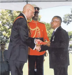  ?? CONTRIBUTE­D ?? Vernal Norman (right) receives the Governor General’s Gold Medal in 2011 for service to education from Governor General Sir Patrick Allen.