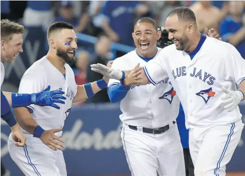  ?? NATHAN DENETTE / THE CANADIAN PRESS ?? Kendrys Morales, right, is congratula­ted by teammates Justin Smoak, left to right, Kevin Pillar and Ezequiel Carrera after hitting a walk- off solo home run in the ninth inning of Wednesday night’s win over the Athletics.