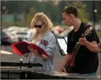  ??  ?? Marimba player Eden Schiller and bass guitarist Moritz Schier, a German exchange student, check the musical score during rehearsal.