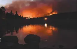  ?? WALLY SKALIJ/LOS ANGELES TIMES ?? The Caldor Fire is reflected off of Caples Lake near the Kirkwood ski resort on Sept. 1 in South Lake Tahoe.