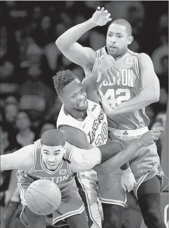  ?? Wally Skalij Los Angeles Times ?? THE LAKERS’ Julius Randle is caught between Boston’s Jayson Tatum, left, and Al Horford as they go after a loose ball. Randle had 14 points and 14 rebounds in the Lakers’ victory.