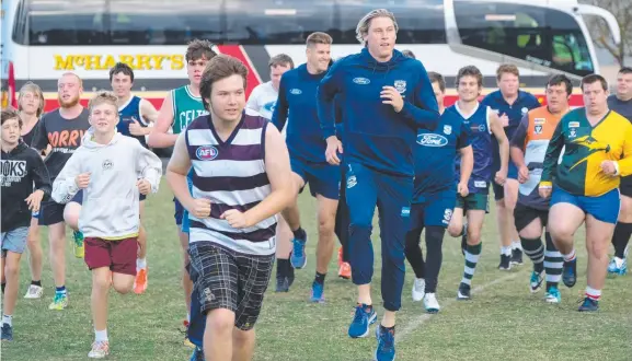  ?? Picture: MARK WILSON ?? CATS AMONG DRAGONS: Geelong players Zac Smith and Mark Blicavs take Geelong’s first all abilities football team through its paces at training.