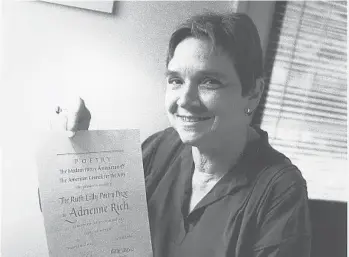  ?? CHUCK KNOBLOCK/AP ?? Adrienne Rich holds her certificat­ion announcing the $25,000 Ruth Lilly Poetry Prize in 1986 in Chicago. Rich was the first poet to receive the award offered specifical­ly to American poets.