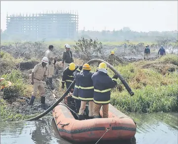  ??  ?? Indian firefighte­rs work next to a doused fire at Bellandur Lake in Bangalore. Bellandur Lake which is among the highly-polluted lakes in the city caught fire due to suspected effluents. — AFP photo