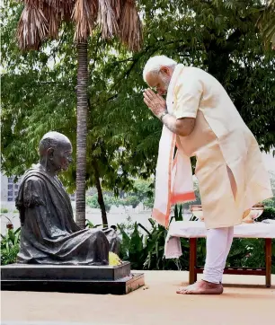  ?? PTI ?? Narendra Modi pays homage to a statue of Mahatma Gandhi in Ahmedabad on Thursday. —