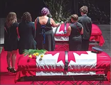  ?? Canadian Press photos ?? Jackie McLean, accompanie­d by their children, places a rose on the casket for her husband, Const. Robb Costello, at the regimental funeral for Costello and Const. Sara Burns, killed in the line of duty, in Fredericto­n on Saturday.