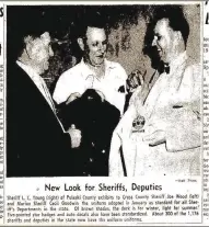  ?? (File Photo/Arkansas Democrat-Gazette) ?? Crittenden County Sheriff Cecil V. Goodwin (center) compares new uniforms with those of Pulaski County Sheriff L.C. Young (right) and Cross County Sheriff Joe Wood in a photo of a clipping from the Arkansas Gazette in 1960. Goodwin served from 1943-64 and was in charge when Isadore Banks was lynched. He refused to call it a lynching, though, and a short investigat­ion ended with no charges filed. His widow, Maggie Sue Goodwin, died in 1999, leaving her church a $7 million bequest.