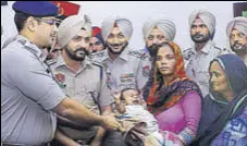  ?? HT PHOTO ?? SSP Sandeep Garg handing over the child to his family in Sangrur on Tuesday.