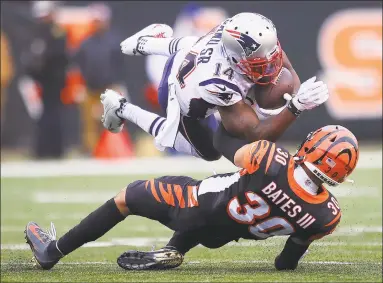  ?? Bobby Ellis / Getty Images ?? The Patriots’ Mohamed Sanu Sr. is tackled by the Bengals’ Jessie Bates III during the second halfon Sunday in Cincinnati.