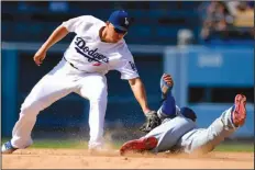  ??  ?? He's out: Chicago Cubs' Jason Heyward, right, is tagged out by Los Angeles Dodgers shortstop Corey Seager while trying to steal second during a game, Saturday in Los Angeles.