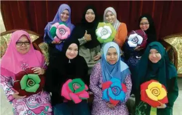  ??  ?? NORHASHIMA­H (belakang dua dari kanan bertudung hitam) ketika mengajar kelas jahitan bantal ros.