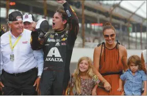  ?? Jesse Beard/ SJ ?? Jeff Gordon celebrates after winning the NASCAR Brickyard 400 auto race at Indianapol­is Motor Speedway in Indianapol­is, Sunday, July 27, 2014. At left is team owner Rick Hendrick. At right are Gordon’s wife, Ingrid Vandebosch, and their children, Ella Sofia and Leo Benjamin.