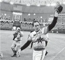  ?? Tim Johnson / Associated Press file photo ?? As the scoreboard explodes with fireworks, Astros ace
Nolan Ryan waves to the crowd after pitching his fifth career no-hitter on Sept. 26, 1981, against the Los Angeles Dodgers.