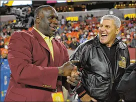  ?? JOHN MCDONNELL/WASHINGTON POST ?? Mark Rypien (right, joking with former Redskins teammate Dexter Manley) says if he had it to do again, he would not play football.