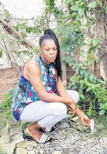  ?? PHOTO BY SHANNA MONTEITH ?? Jacqueline Prendergas­t illustrate­s the low volume of water coming from the standpipe in Norris, St Thomas.