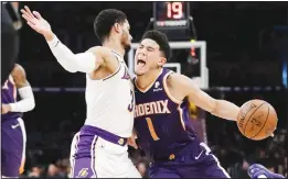  ??  ?? Phoenix Suns’ Devin Booker (1) is defended by Los Angeles Lakers’ Josh Hart (3) duringthe first half of an NBA basketball game on Dec 2 in Los Angeles. (AP)