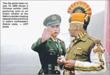  ??  ?? This file photo taken on July 10, 2008 shows a Chinese soldier ( left) gesturing next to an Indian soldier at the Nathu La border crossing between India and China in India’s northeaste­rn Sikkim state. — AFP photo