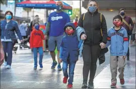  ?? Mel Melcon Los Angeles Times ?? GETTING people like this family from Commerce to wear masks is easier for President- elect Joe Biden than convincing those for whom the issue is political.