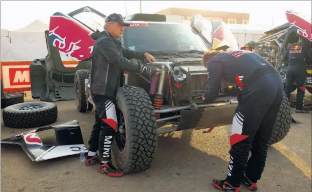  ??  ?? Carlos Sainz y Lucas Cruz trabajan sobre el Mini a la llegada a Sakaka, fin de la séptima etapa, que está marcada por ser la primera parte de la etapa maratón.