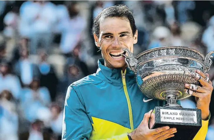  ?? ?? Rafa Nadal mossegant el trofeu en una imatge que pràcticame­nt s’ha convertit en rutinària