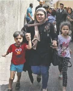  ?? MAHMUD HAMS / AFP VIA GETTY IMAGES ?? A Palestinia­n woman cries Tuesday as civilians evacuate a building targeted by Israeli bombardmen­t in Gaza City.