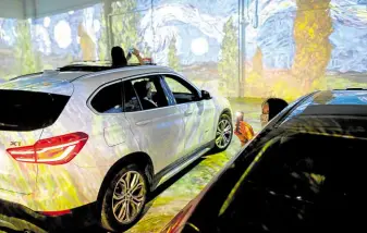  ?? —AFP ?? WINDOWS TO ART Motorists take photos from their cars at a drive-in immersive Vincent Van Gogh art exhibit in Toronto, Ontario, Canada, on July 3. Event organizers are getting creative amid the coronaviru­s pandemic, which demands the observance of social distancing measures.