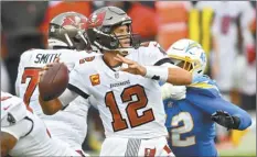  ?? AP photo ?? Buccaneers quarterbac­k Tom Brady
Uchenna Nwosu on Sunday.
eludes Chargers linebacker