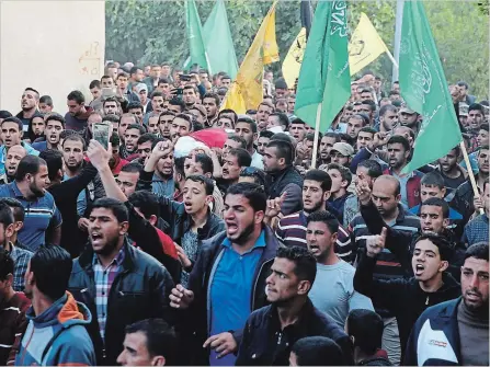  ?? ADEL HANA
THE ASSOCIATED PRESS ?? Crowds protest while they carry Osama Qudeihm, 38, a Hamas police officer killed durning clashes with Israeli troops along Gaza's border.