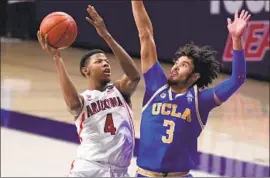  ?? Rick Scuteri Associated Press ?? ARIZONA’S Dalen Terry (4) shoots over Johnny Juzang, who contribute­d a career-best 16 points as UCLA won its fourth straight game at McKale Center.