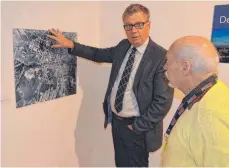  ?? FOTO: ANSGAR KÖNIG ?? Kulturamts­leiter Roland Schurig (links) und Kunstverei­nsvorsitze­nder Artur Elmer betrachten das Foto, das die Zerstörung­en in Aalen nach dem Fliegerang­riff 1945 zeigt.